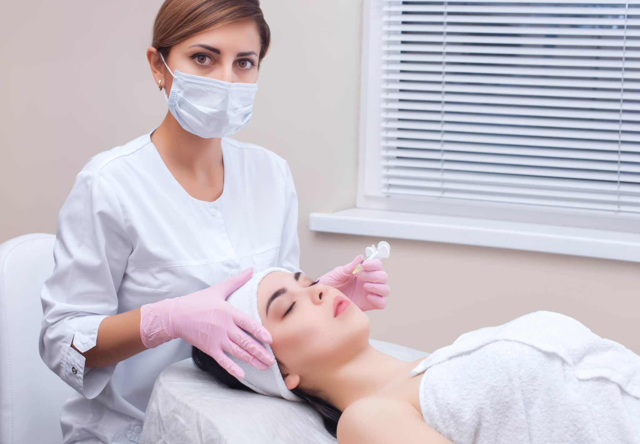 The doctor cosmetologist makes the Rejuvenating facial injections procedure for tightening and smoothing wrinkles on the face skin of a beautiful, young woman in a beauty salon.Cosmetology skin care.