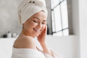 woman in spa bathrobe and towel relaxing after taking shower bath