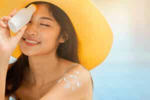 woman applying sunscreen and holding holding blank sunscreen UV protective lotion