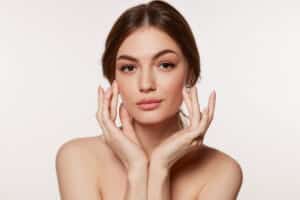 A woman posing with her hands under her chin, showing the results of Clear + Brilliant Touch