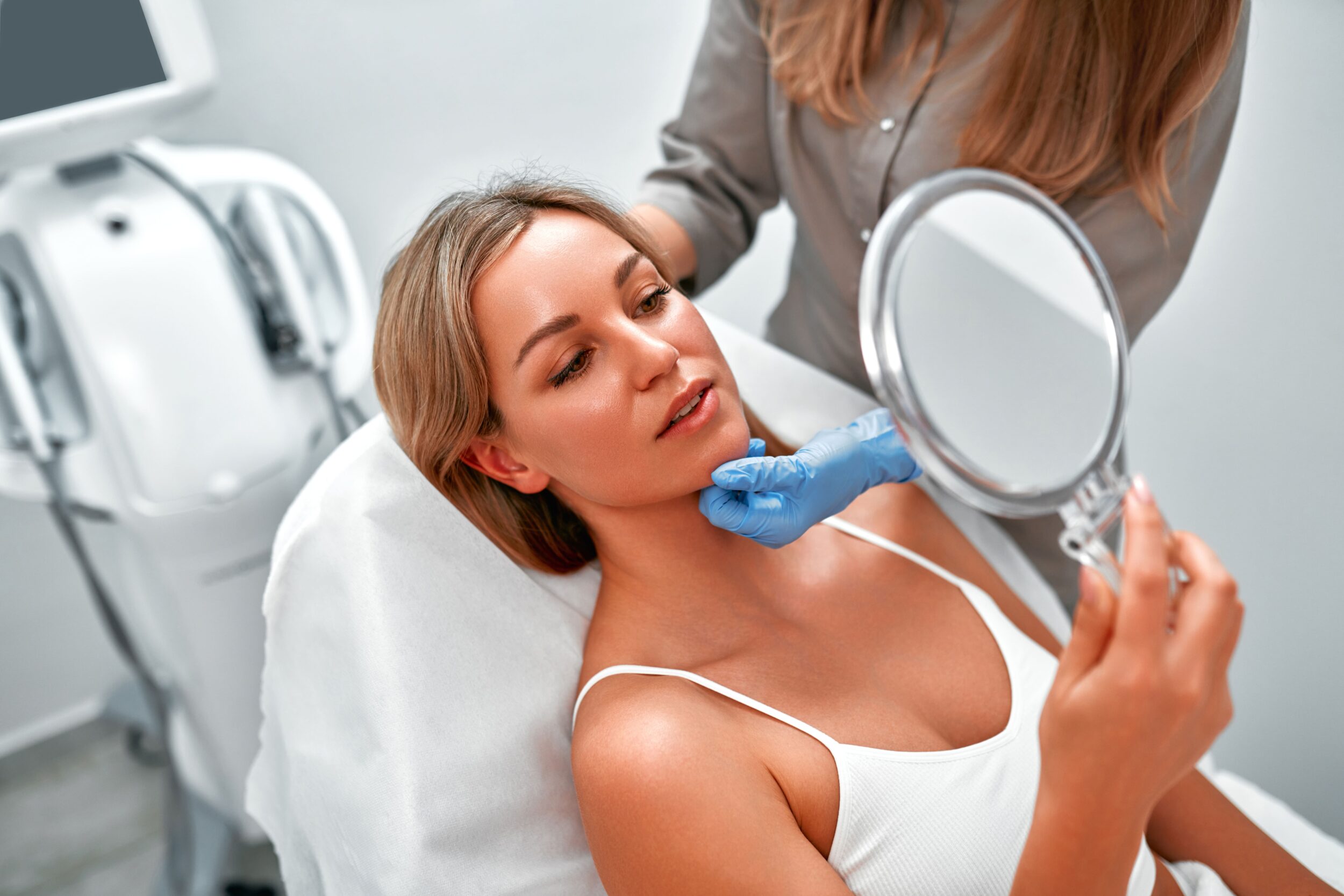 A woman looking in the mirror after AnteAGE biosome treatments in Mount Pleasant