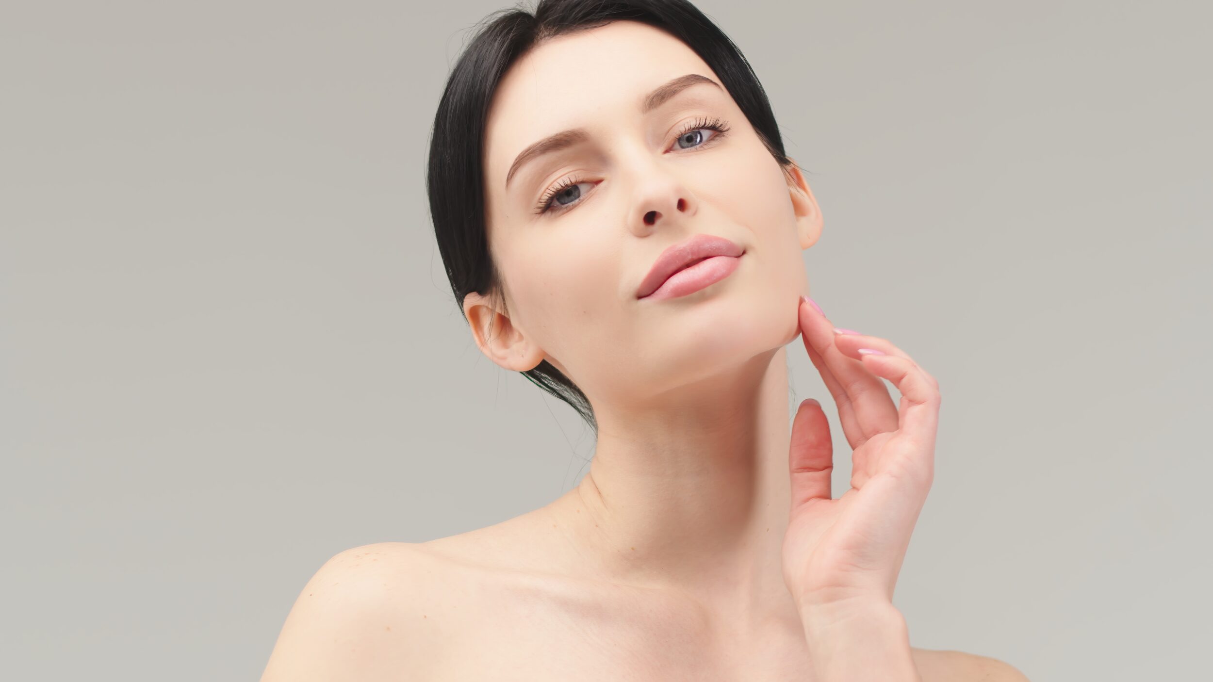 A woman touching her jaw showing the results of AnteAGE biosomes