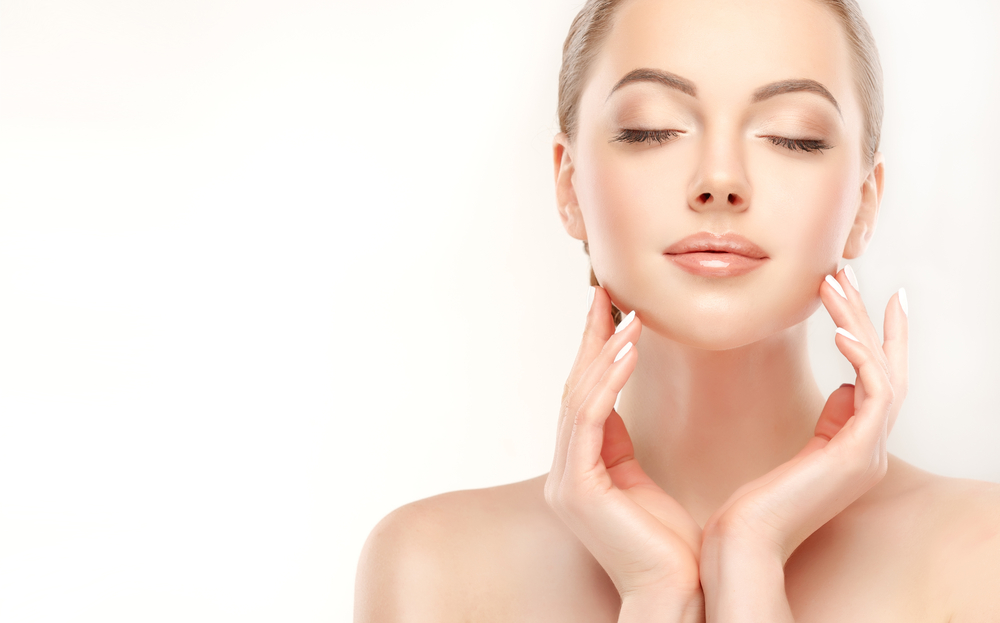 Woman with eyes closed and hands framing her smooth, refreshed complexion.